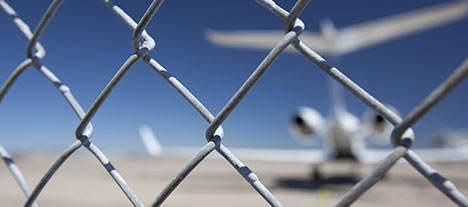 chain link fence with blurry jet at a distance